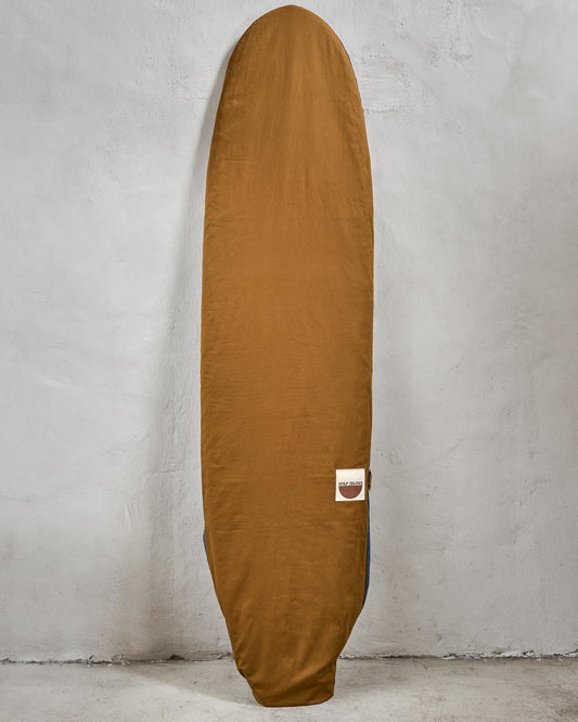 Handmade brown surfboard bag with a logo on a grey background.