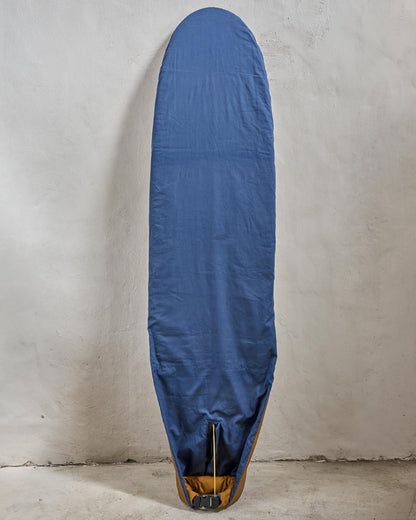 Handmade blue surfboard cover on a longboard against a grey wall.